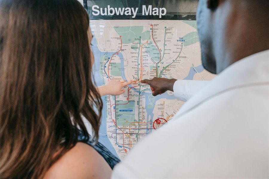 A couple pointing at a subway map